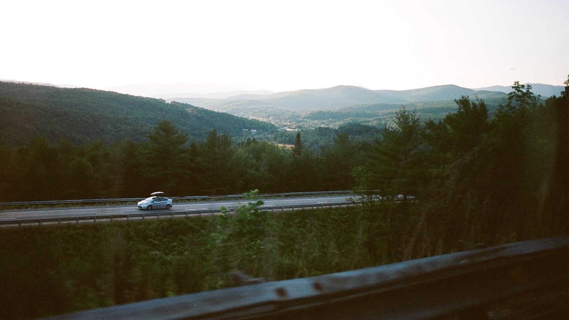Ein Auto in den grünen Hügeln von Vermont.
