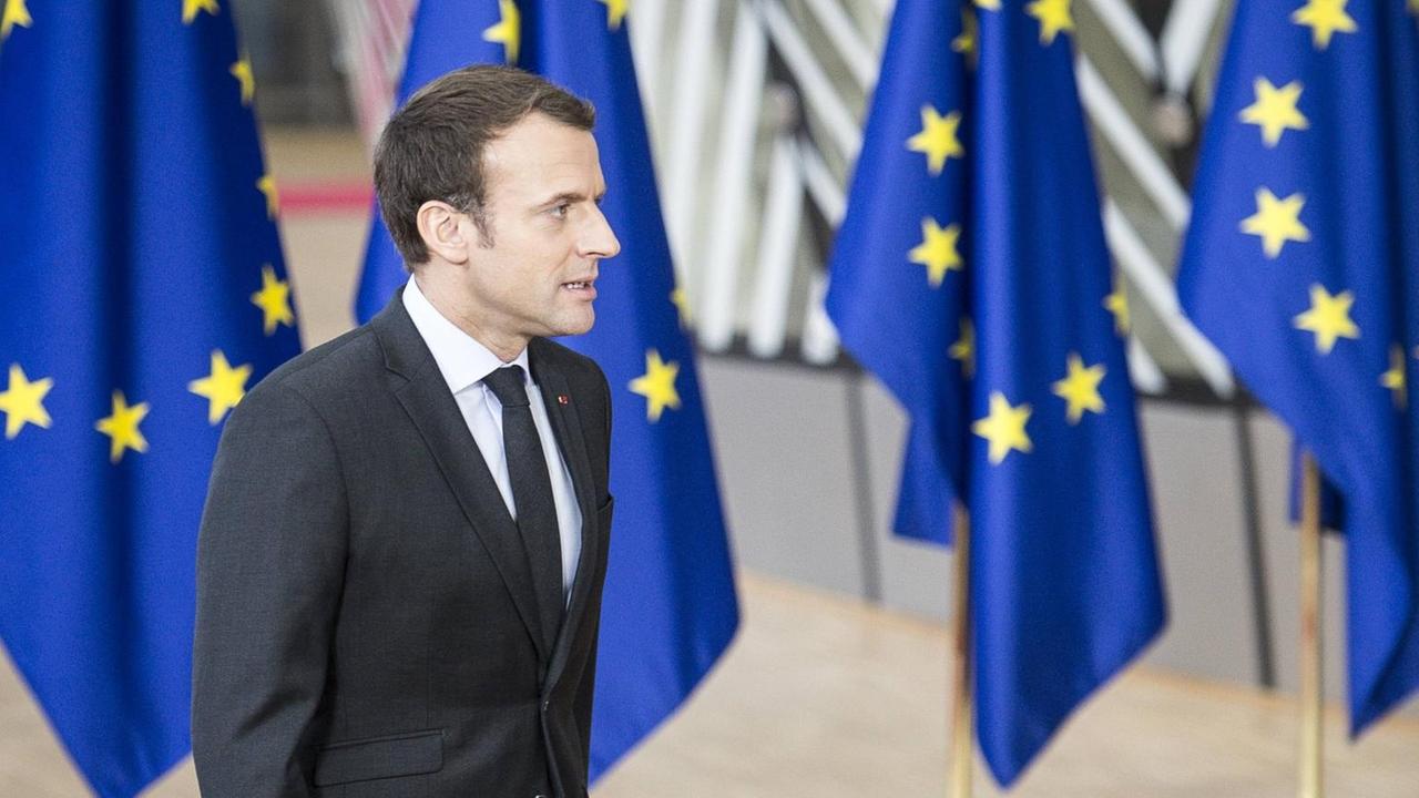 Der französische Präsident Emmanuel Macron beim EU-Gipfeltreffen in Brüssel vor einer Reihe von Europafahnen.