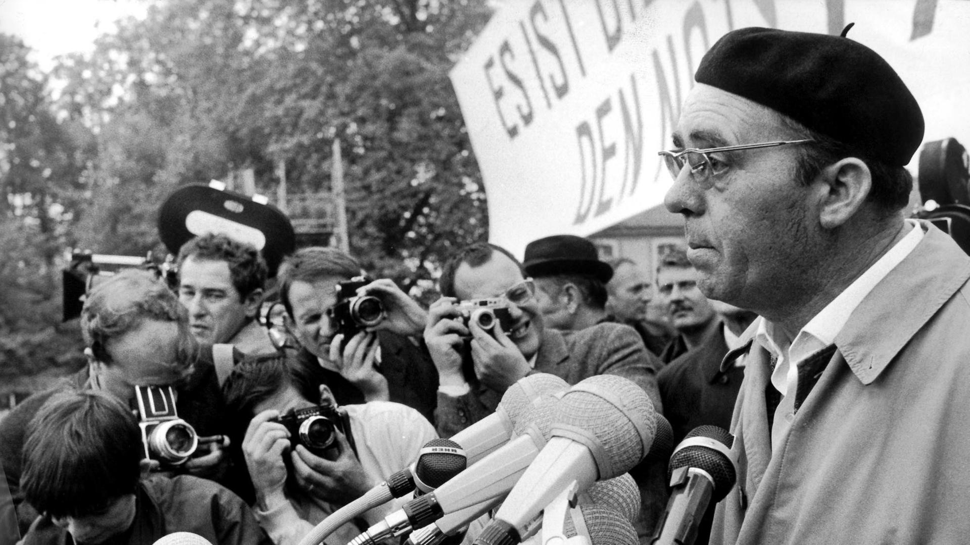 Der Schriftsteller Heinrich Böll spricht zu den Teilnehmern der Kundgebung im Bonner Hofgarten. Am 11. Mai 1968 fand in Bonn eine Großdemonstration gegen die Notstandsgesetze statt. Nach einem Sternmarsch versammelten sich die Demonstranten zu einer Kundgebung im Bonner Hofgarten.