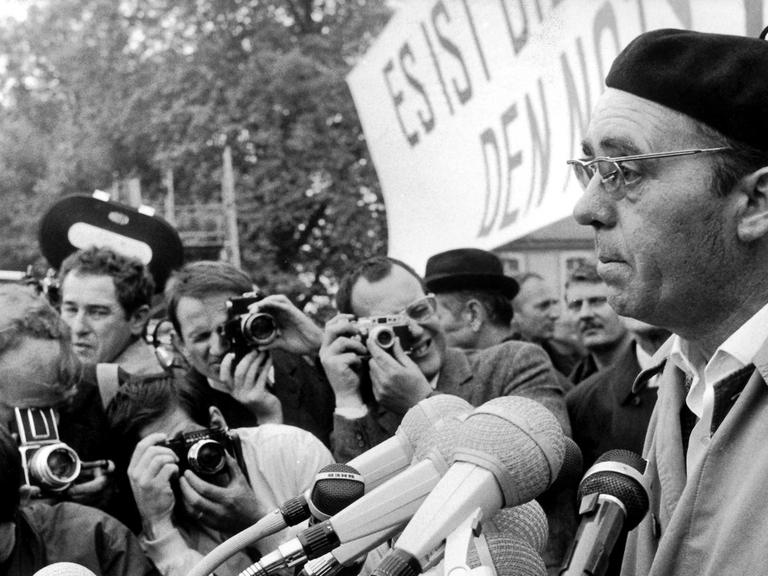 Der Schriftsteller Heinrich Böll spricht zu den Teilnehmern der Kundgebung im Bonner Hofgarten. Am 11. Mai 1968 fand in Bonn eine Großdemonstration gegen die Notstandsgesetze statt. Nach einem Sternmarsch versammelten sich die Demonstranten zu einer Kundgebung im Bonner Hofgarten.