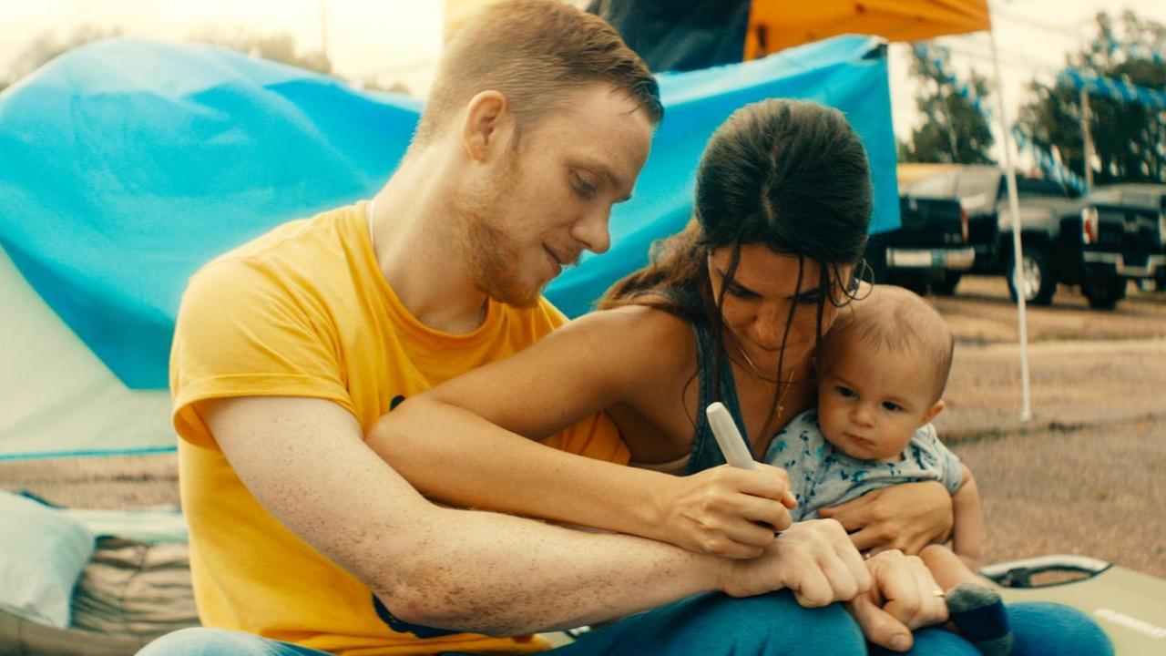 Filmstill aus "One of These Days": Ein Mann, eine Frau und ein Baby am Strand.