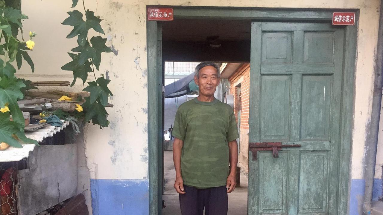 Chen Shengzhang vor seinen roten Plaketten Chen Shengzhang vor seinen roten Plaketten