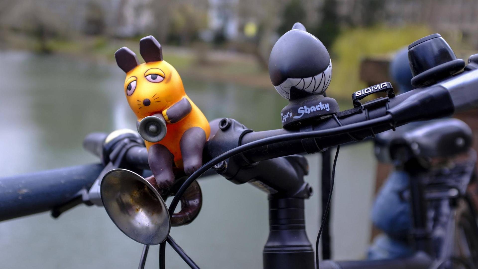 29.02.2020, Duesseldorf, Nordrhein-Westfalen, Deutschland - Fahrradhupe in Form der Maus aus der Fernsehsendung "Die Sendung mit der Maus" an einem Fahrradlenker vor einem Teich in Duesseldorf 29.02.2020, Duesseldorf, Nordrhein-Westfalen, Deutschland - Fahrradhupe in Form der Maus aus der Fernsehsendung "Die Sendung mit der Maus" an einem Fahrradlenker vor einem Teich in Duesseldorf