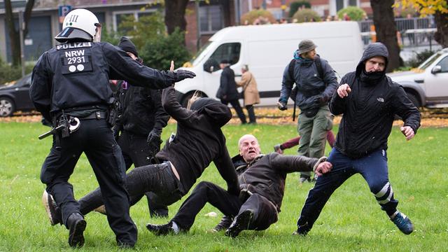 Polizisten in Köln versuchen eine Prügelei zwischen Teilnehmern der Hogesa-Proteste und Gegendemonstranten zu beenden.