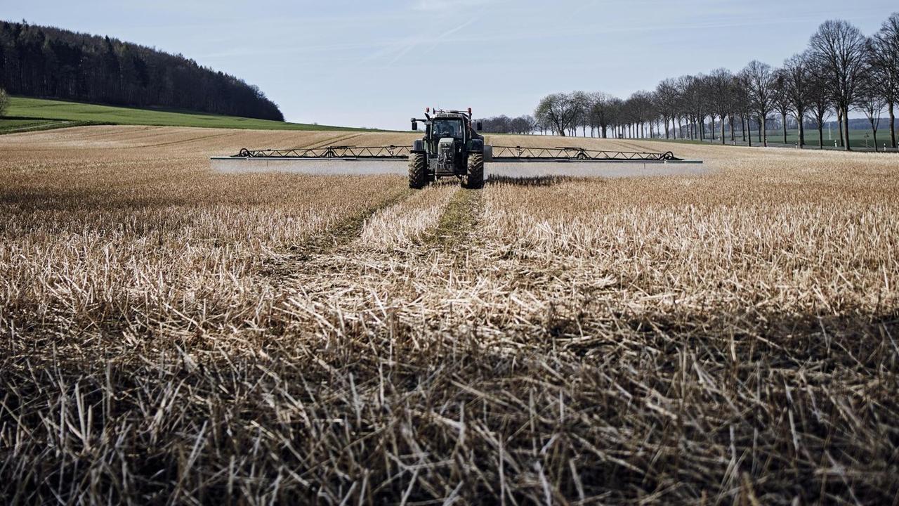 Ein Traktor bringt Glyphosat auf einem Feld in Niedersachsen aus Ein Traktor bringt Glyphosat auf einem Feld in Niedersachsen aus