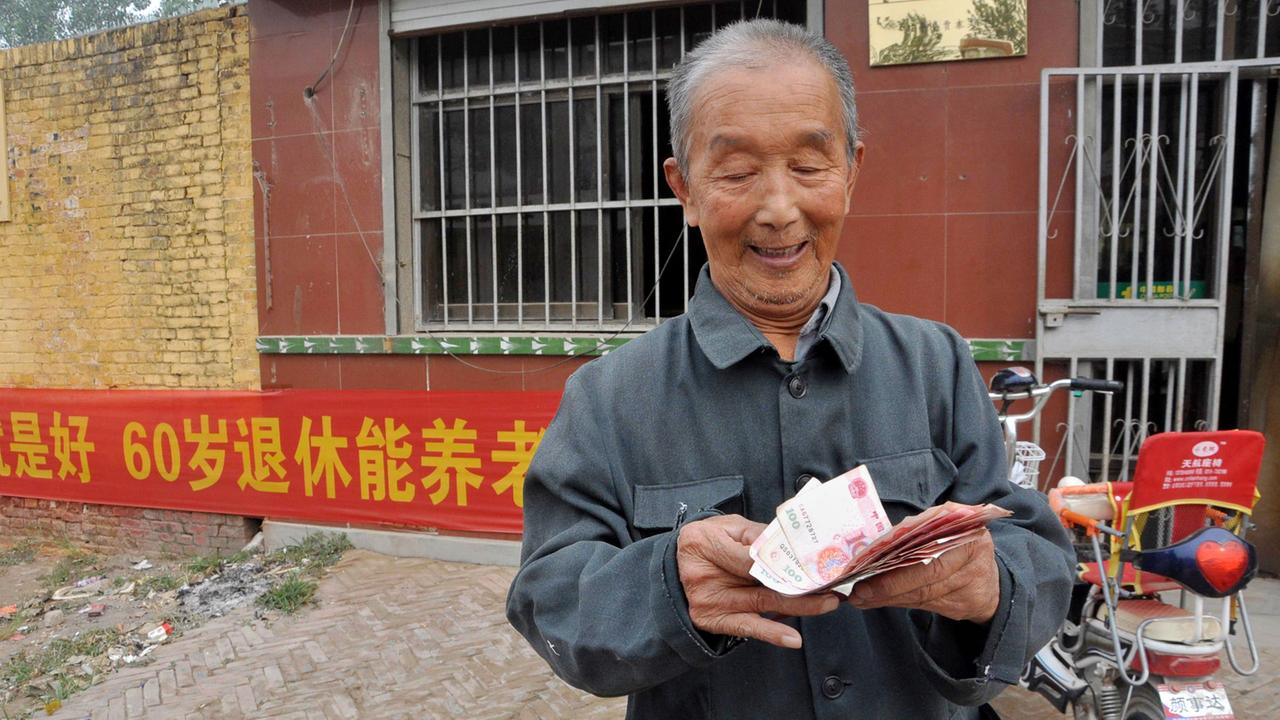 Ein älterer Chinese zählt sein Geld. Ein älterer Chinese zählt sein Geld.