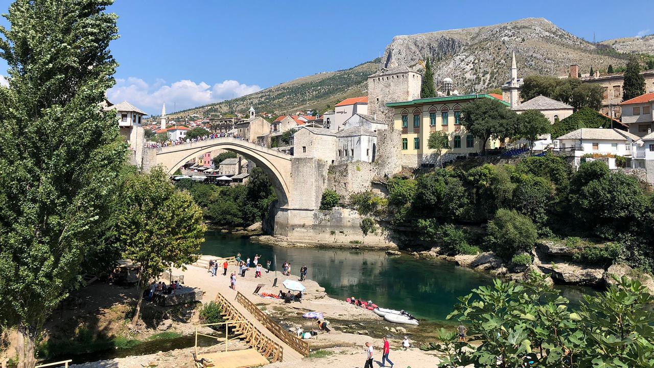 Touristen strömen über das Wahrzeichen von Mostar: die wiederaufgebaute Brücke über die Neretva. Touristen strömen über das Wahrzeichen von Mostar: die wiederaufgebaute Brücke über die Neretva.