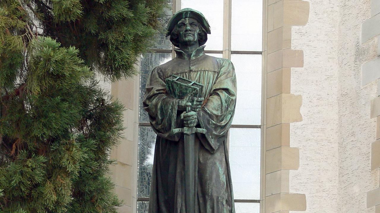 Ein Standbild des Reformators Ulrich Zwingli vor der Wasserkirche in Zürich Ein Standbild des Reformators Ulrich Zwingli vor der Wasserkirche in Zürich