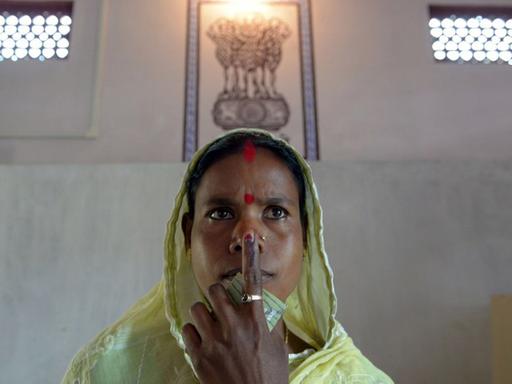 Eine Frau in Indien posiert nach der Stimmabgabe für ein Foto in einem Wahllokal in Indien.