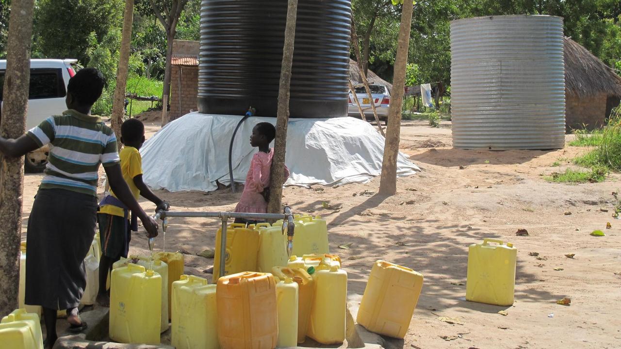 Südsudanesen warten auf den Wassertruck im Rhinocamp. Gelbe Wasserkanisten sind leer. Südsudanesen warten auf den Wassertruck im Rhinocamp. Gelbe Wasserkanisten sind leer.