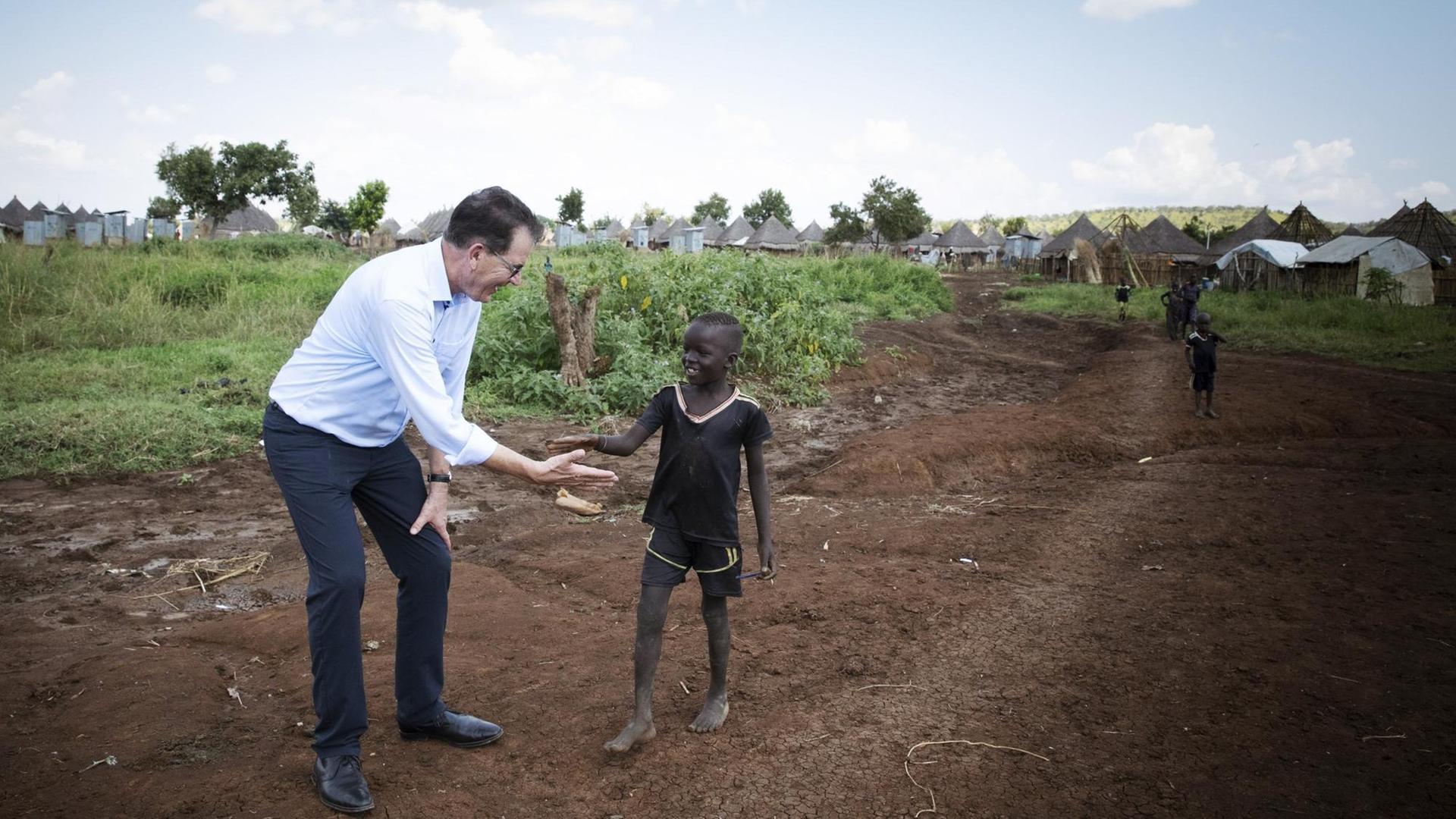 Bundesentwicklungsminister Gerd Müller (CSU) reicht einem kleinen Jungen die Hand. Bundesentwicklungsminister Gerd Müller (CSU) reicht einem kleinen Jungen die Hand.