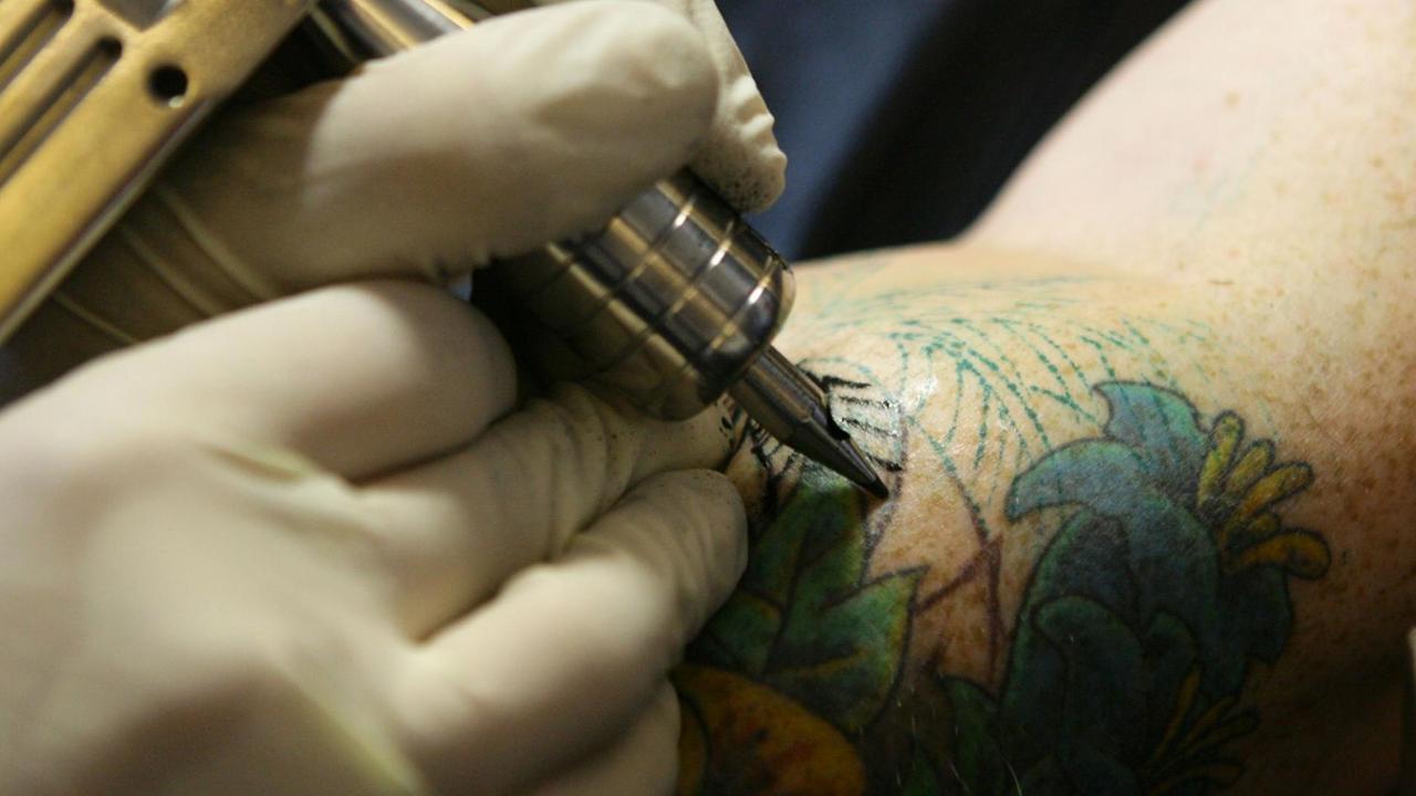 Ein Mann lässt sich ein Tattoo stechen. Ein Mann lässt sich ein Tattoo stechen.