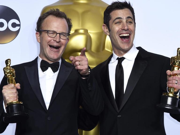 Tom McCarthy und Josh Singer halten während der Preisverleihung am 28.02.2016 im Dolby-Theater/Hollywood in Los Angeles/USA den "Oskar" hoch, den sie für die beste Regie erhalten haben.