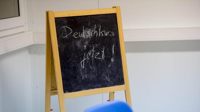 Eine Tafel weist in einer Berliner Flüchtlingsunterkunft auf einen Deutschkurs hin.