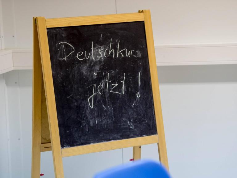 Eine Tafel weist in einer Berliner Flüchtlingsunterkunft auf einen Deutschkurs hin.