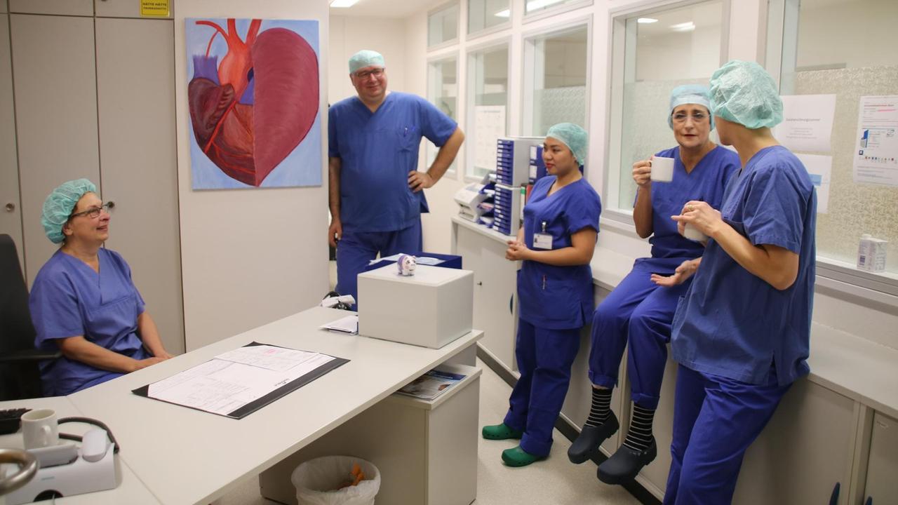 Daisy steht mit ihren Kollegen im Pausenraum des Uniklinikum Bonn. Daisy steht mit ihren Kollegen im Pausenraum des Uniklinikum Bonn.