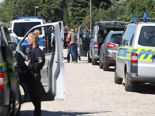 Polizeifahrzeuge stehen auf einer Straße im Ort Reuden bei Zeitz in Sachsen-Anhalt.