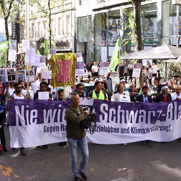 Auszug aus einem Videobericht der Zeitung Der Standard. Der Screenshot zeigt die Spitze des Demonstrationszugs mit der Spruchband "Nie wieder Schwarz-Blau." 