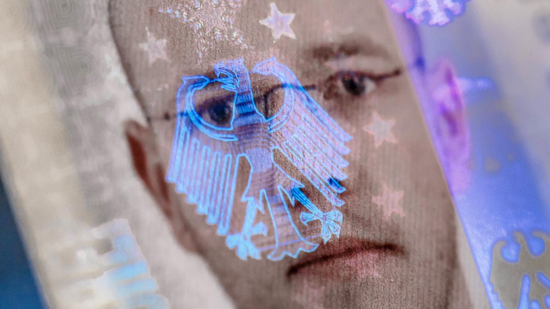 Auf dem Biometrischen Passfoto eines Personalausweises spiegelt sich ein Bundesadler als Hologramm
