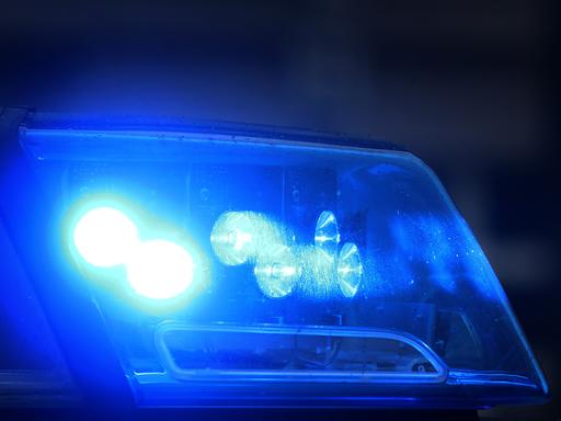 Blaulicht eines Polizeiautos, das von einer Pkw-Fensterscheibe reflektiert wird