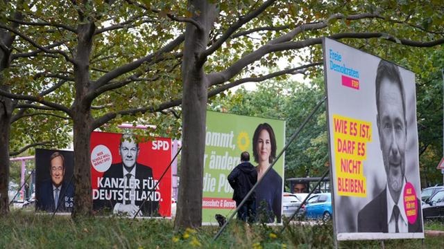 Wahlplakate der Union mit Armin Laschet, der SPD mit Olaf Scholz, von Bündnis 90/Die Grünen mit Annalena Baerbock und der FDP mit Christian Lindner stehen einen Tag nach der Bundestagswahl in einer Reihe.