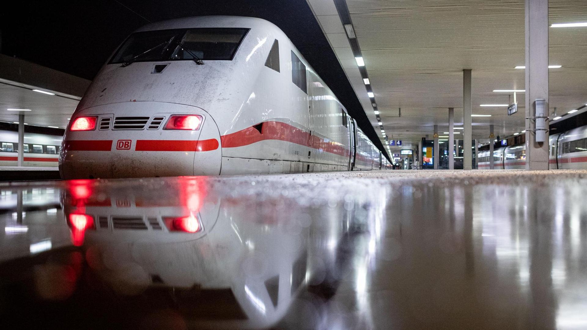 Der Zug steht an einem Gleis, das Bild ist fast aus Bodenhöhe aufgenommen. Der Boden glänz nass. Der Zug steht an einem Gleis, das Bild ist fast aus Bodenhöhe aufgenommen. Der Boden glänz nass.