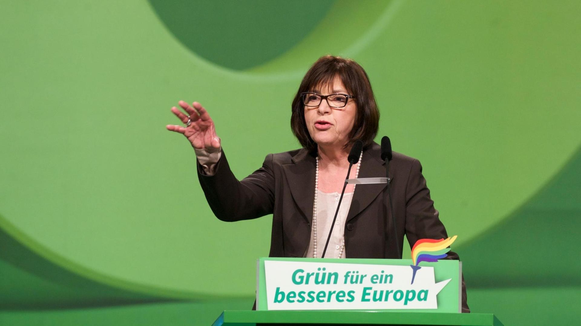 Grünen-Politikerin Rebecca Harms steht vor grünem Hintergund an einem ebenfalls grünen Rednerpult mit der Aufschrift: "Grün für ein besseres Europa". Sie spricht und gestikuliert, indem sie ihre rechte Hand hebt. Grünen-Politikerin Rebecca Harms steht vor grünem Hintergund an einem ebenfalls grünen Rednerpult mit der Aufschrift: "Grün für ein besseres Europa". Sie spricht und gestikuliert, indem sie ihre rechte Hand hebt.