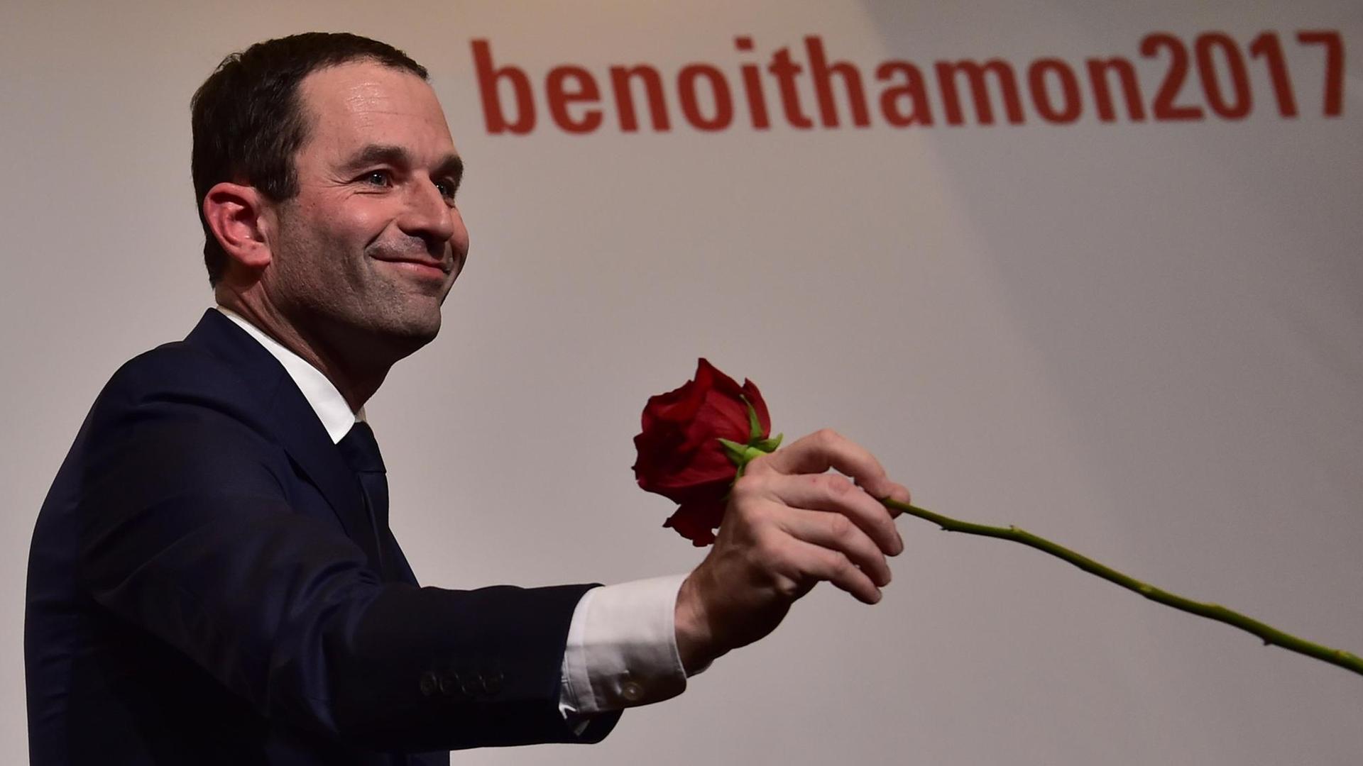 Der Präsidentschaftskandidat der französischen Sozialisten, Benoit Hamon, hält eine Rose in der Hand.