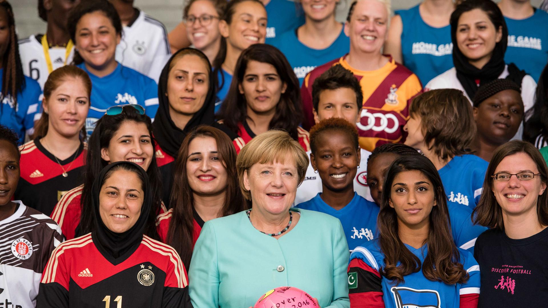 Das Fußball-Frauenteam "Discover Football" bei Merkel. Bundeskanzlerin Angela Merkel (CDU, Mitte) posiert am 01.09.2016 gemeinsam mit Fußballerinnen des Projektes «Discover Football» im Bundeskanzleramt in Berlin für ein gemeinsames Foto. Das Projekt «Discover Football» setzt sich mithilfe des Fußballs weltweit für Gleichberechtigung und Frauenrechte ein. Das Fußball-Frauenteam "Discover Football" bei Merkel. Bundeskanzlerin Angela Merkel (CDU, Mitte) posiert am 01.09.2016 gemeinsam mit Fußballerinnen des Projektes «Discover Football» im Bundeskanzleramt in Berlin für ein gemeinsames Foto. Das Projekt «Discover Football» setzt sich mithilfe des Fußballs weltweit für Gleichberechtigung und Frauenrechte ein.