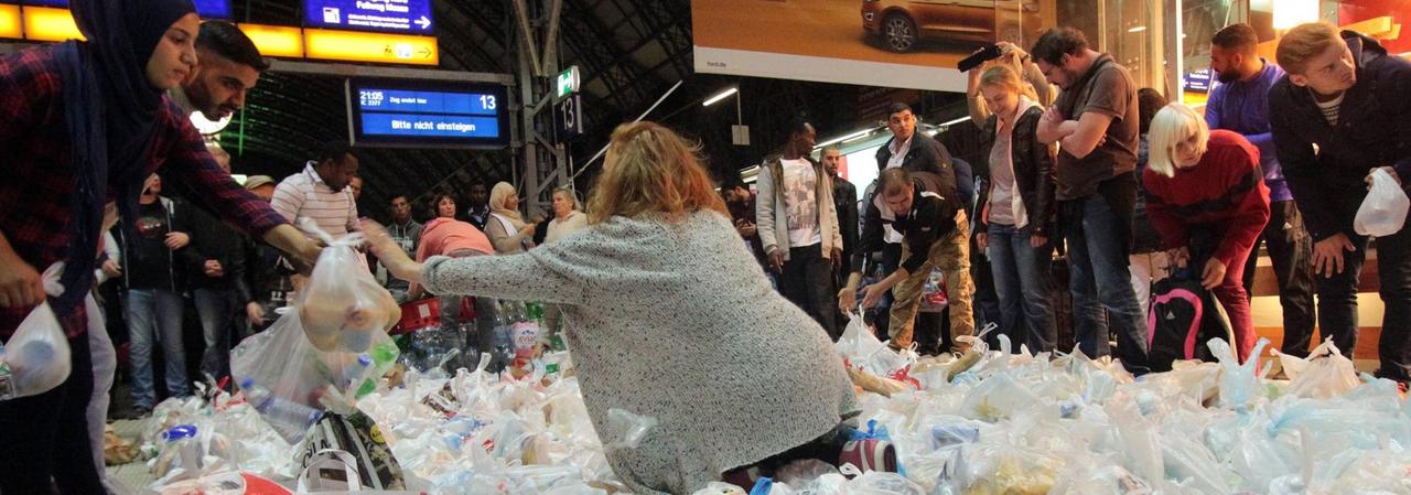 Eine ehrenamtliche Helferin verteilt am Frankfurter Bahnhof Essenspakete an Flüchtlinge. Eine ehrenamtliche Helferin verteilt am Frankfurter Bahnhof Essenspakete an Flüchtlinge.