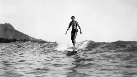 Honolulu, Hawaii, 1929: Ein Surfer reitet vor Waikiki BEach auf einer Welle. Es handelt sich vermutlich um Duke Kahanamoku.