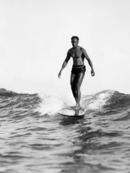 Honolulu, Hawaii, 1929: Ein Surfer reitet vor Waikiki BEach auf einer Welle. Es handelt sich vermutlich um Duke Kahanamoku.
