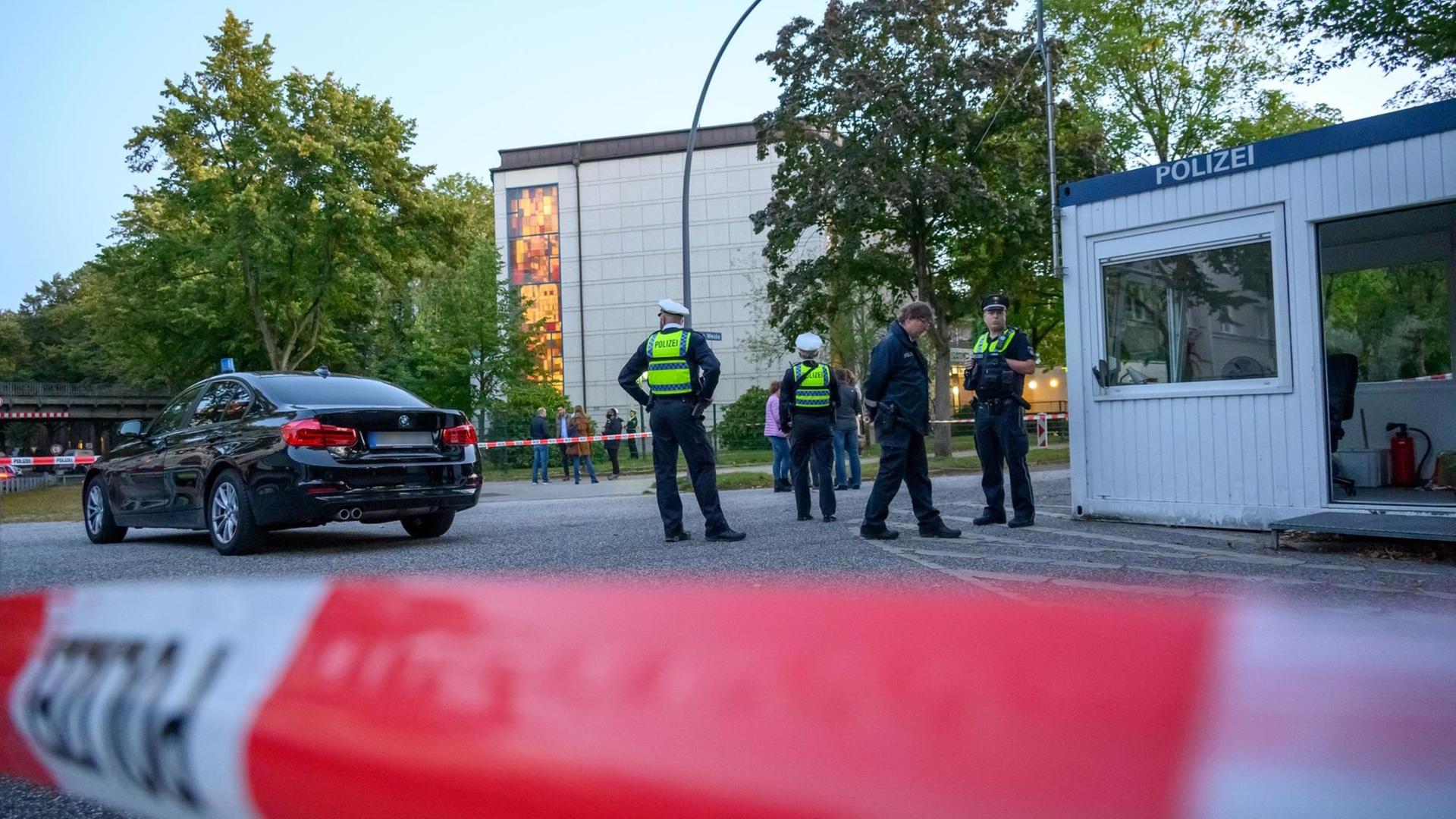 Mehrere Polizeibeamte und Zivilisten stehen im abgesperrten Bereich vor der Synagoge. Mehrere Polizeibeamte und Zivilisten stehen im abgesperrten Bereich vor der Synagoge.