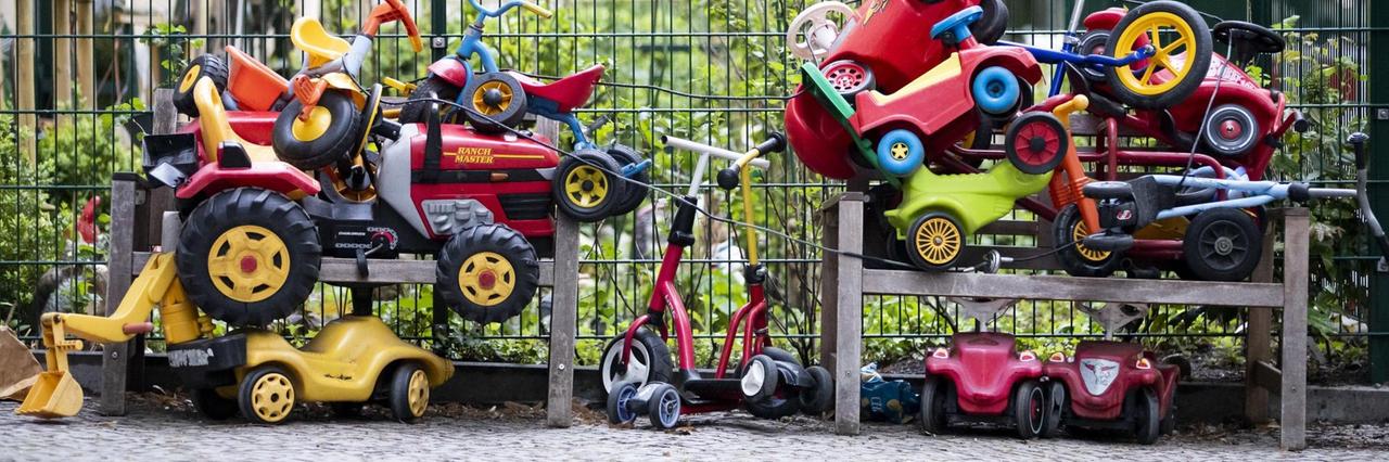 Bobbycars und Kinderfahrräder stapeln sich angeschlossen vor einer Kita in Berlin-Wilmersdorf. Bobbycars und Kinderfahrräder stapeln sich angeschlossen vor einer Kita in Berlin-Wilmersdorf.