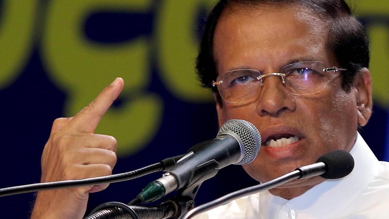 Maithripala Sirisena spricht mit entschlossenem Gesichtsausdruck in ein Mikrofon. Maithripala Sirisena spricht mit entschlossenem Gesichtsausdruck in ein Mikrofon.