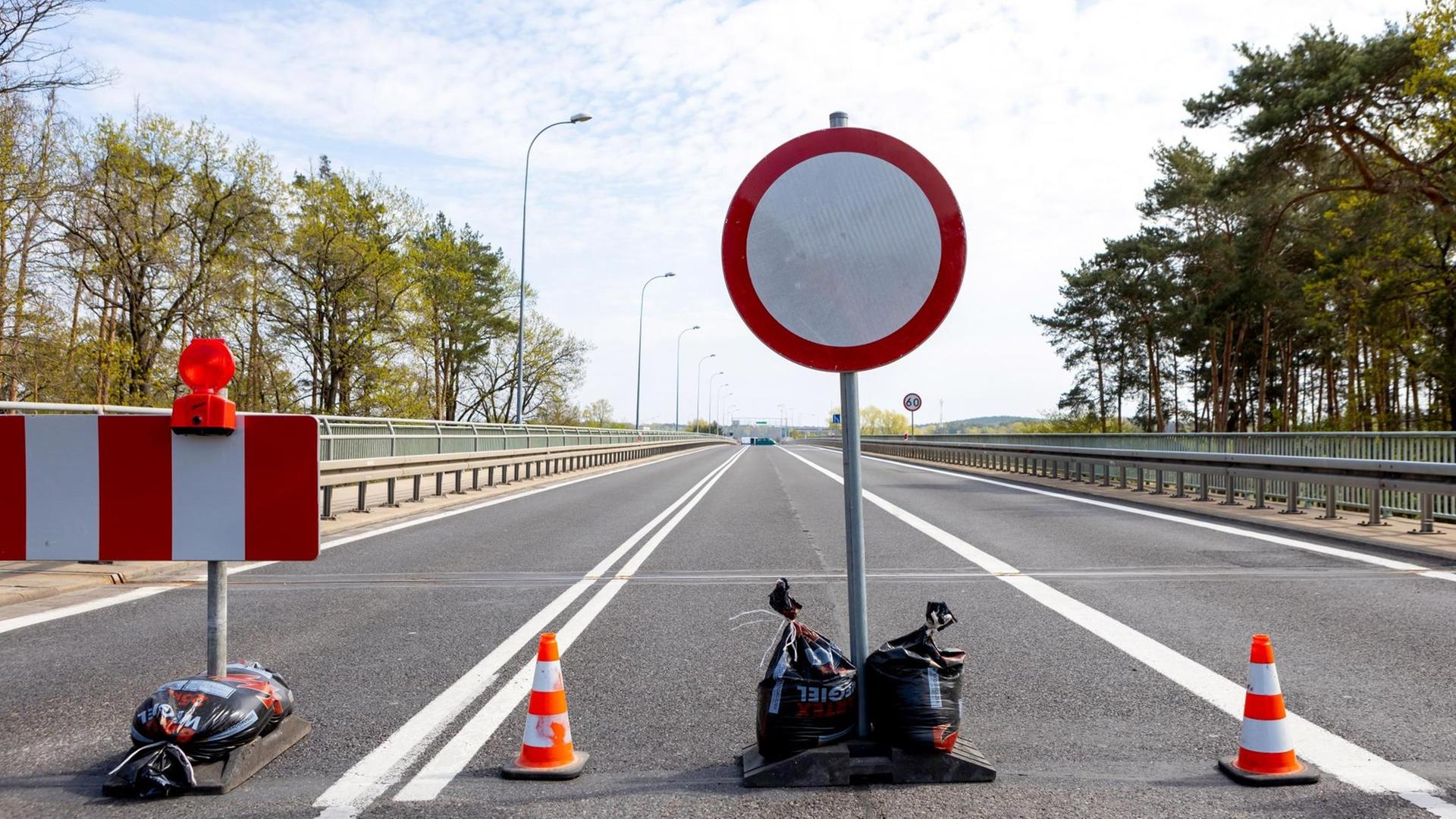 Ein Sperr-Schild und eine Barrikade an einer geschlossenen Grenze Ein Sperr-Schild und eine Barrikade an einer geschlossenen Grenze