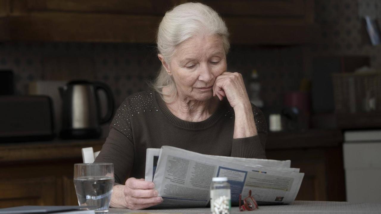 Eine Seniorin liest Zeitung