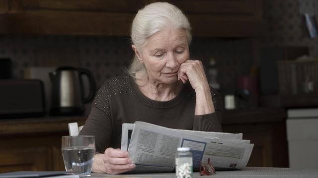 Eine Seniorin liest Zeitung