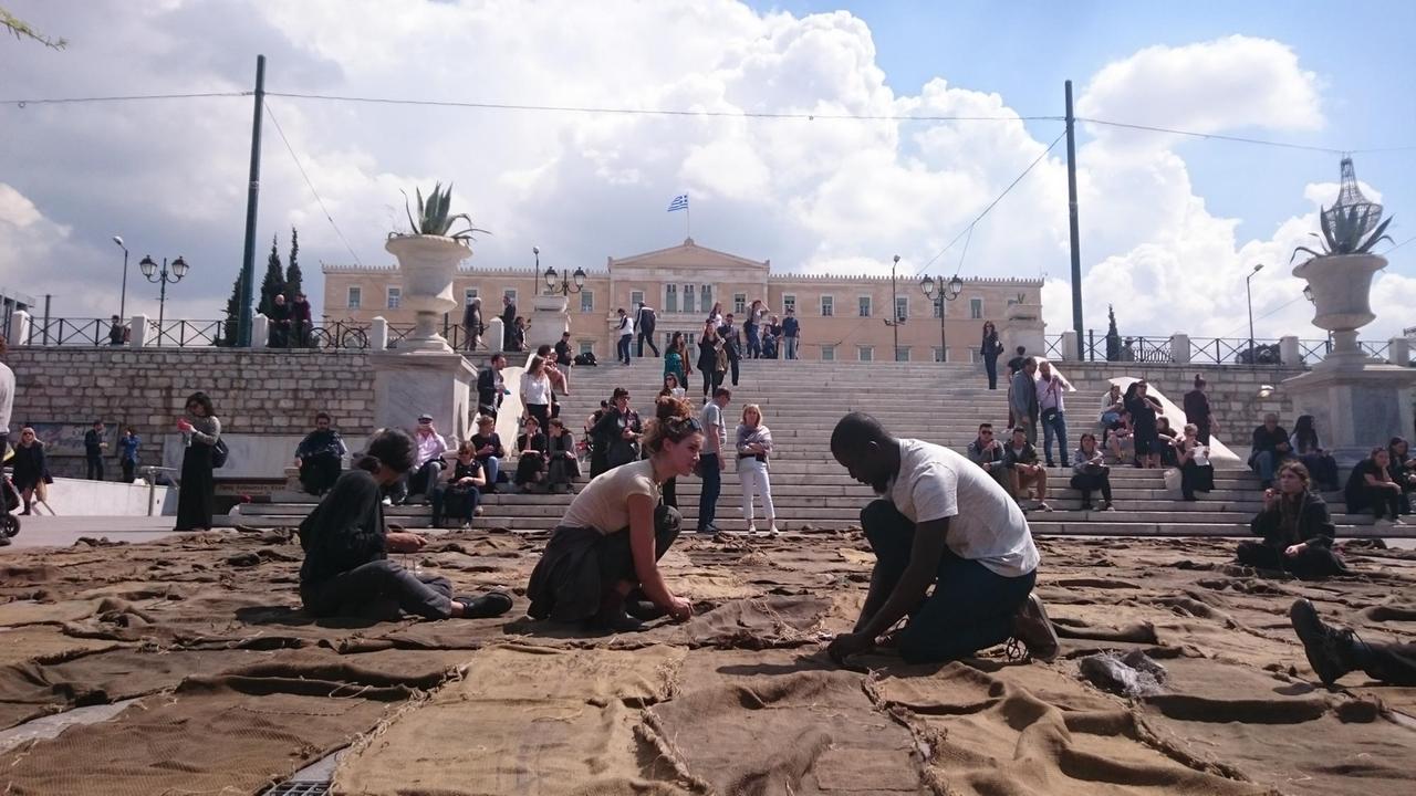 Helfer nähen auf dem Syntagma-Platz unzählige gebrauchte Jutesäcke zu einem Teppich zusammen. Helfer nähen auf dem Syntagma-Platz unzählige gebrauchte Jutesäcke zu einem Teppich zusammen.