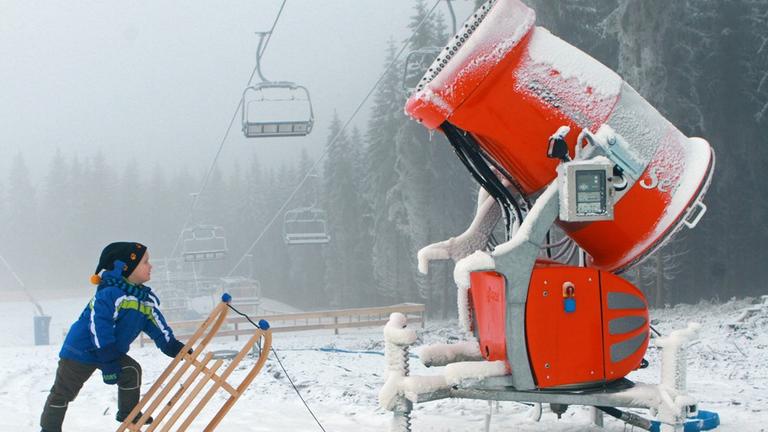 Der kleine Konstantin steht am 22.01.2014 mit seinem Schlitten vor einer Schneekanone in Braunlage Der kleine Konstantin steht am 22.01.2014 mit seinem Schlitten vor einer Schneekanone in Braunlage