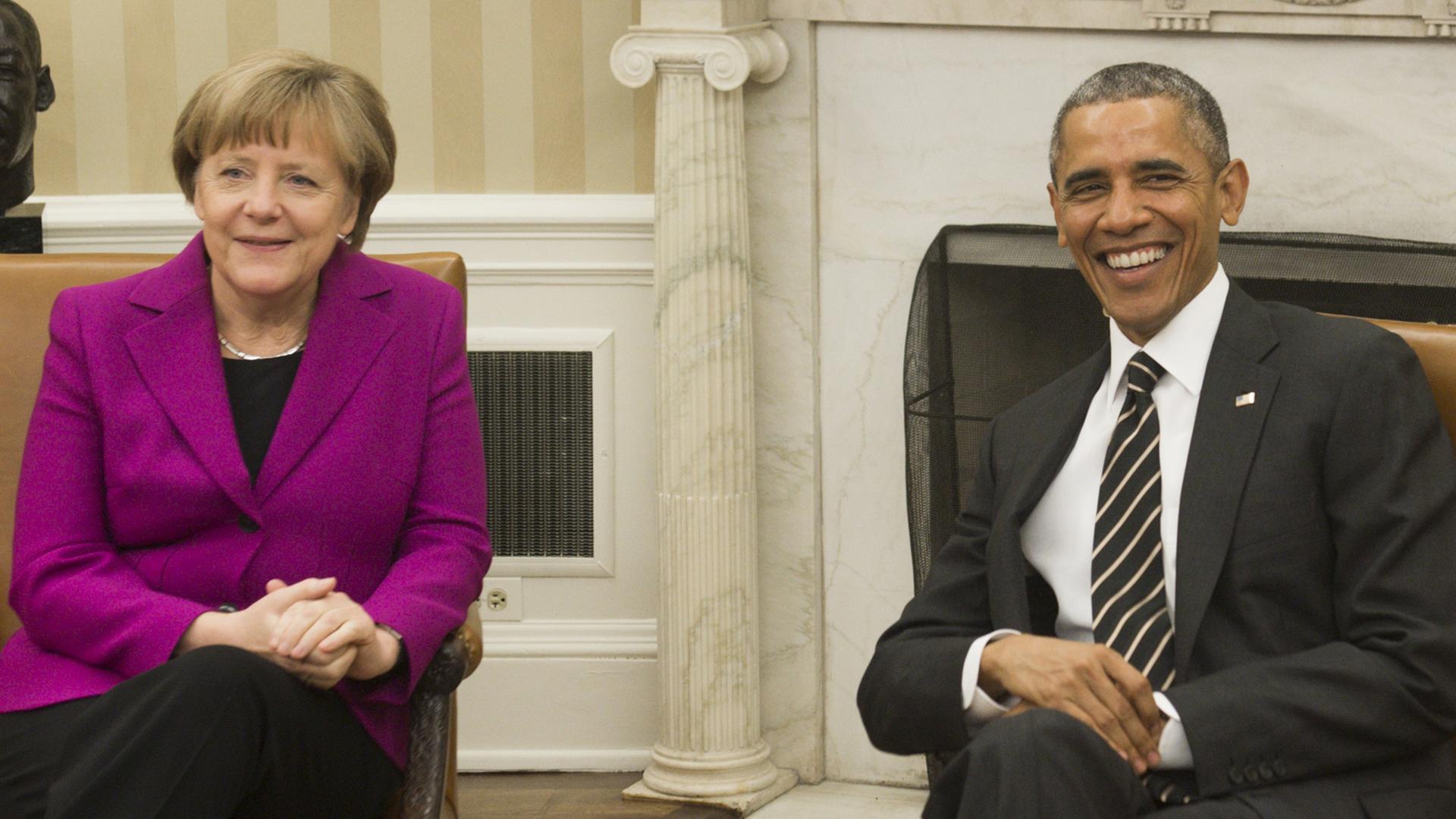 Bundeskanzlerin Angela Merkel und US-Präsident Barack Obama im Oval Office. Beide lachen in die Kameras. Bundeskanzlerin Angela Merkel und US-Präsident Barack Obama im Oval Office. Beide lachen in die Kameras.