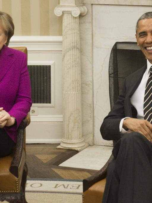 Bundeskanzlerin Angela Merkel und US-Präsident Barack Obama im Oval Office. Beide lachen in die Kameras.