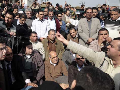 Mohamed El Baradei (Mitte,sitzend) wird von anderen Protestierenden vor den Freitagsgebeten in Kairo begrüßt.
