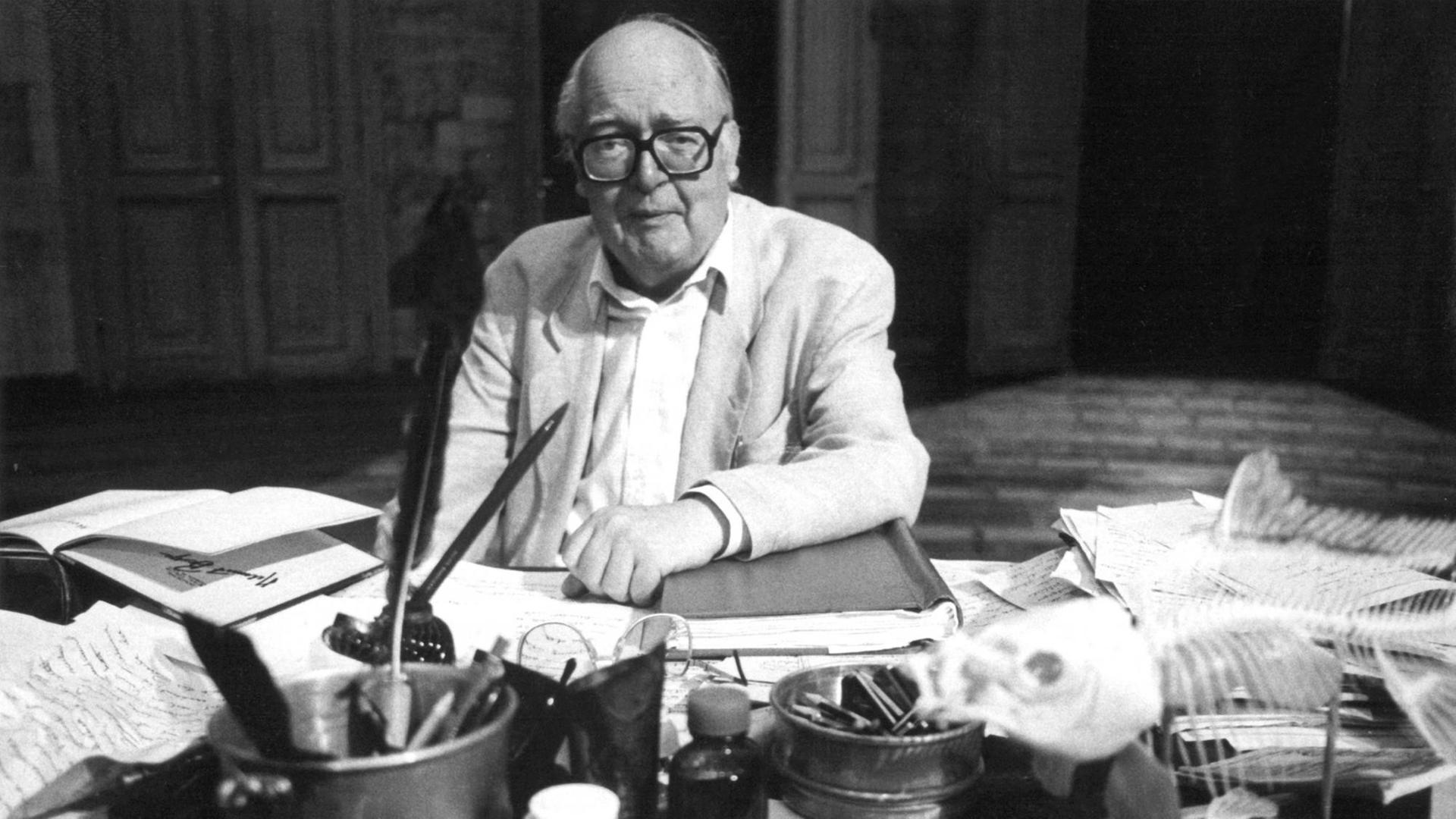 Friedirch Dürrenmatt sitzt an einem großen Schreitisch. (1988) Friedirch Dürrenmatt sitzt an einem großen Schreitisch. (1988)