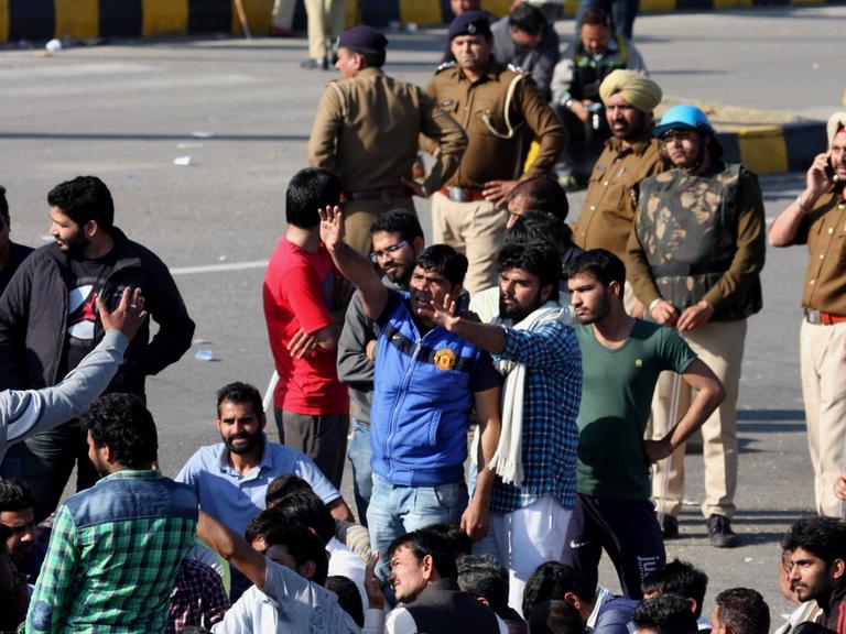 Angehörige der Jat blockieren eine Autobahn in Panchkula. Es sind Menschen in aufgeregter Diskussion zu sehen.