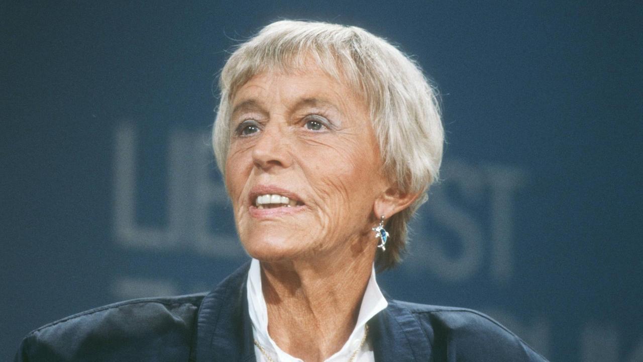 Ein Portrait der weisshaarigen Unternehmerin Beate Uhse. Sie trägt eine Bluse und einen Blazer und hält gerade eine Rede. Ein Portrait der weisshaarigen Unternehmerin Beate Uhse. Sie trägt eine Bluse und einen Blazer und hält gerade eine Rede.