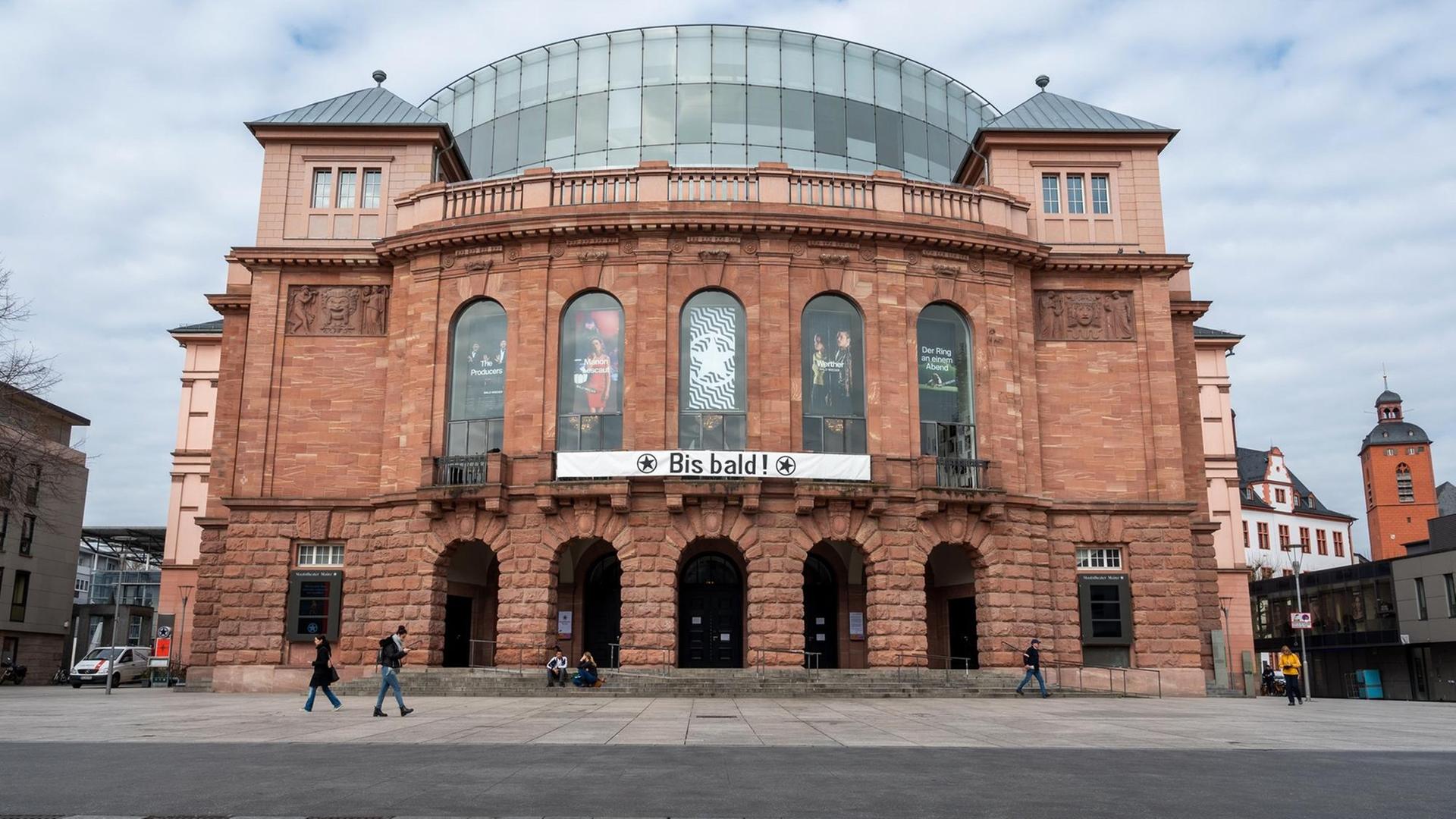Das Staatstheater Mainz hat nach seiner Schließung wegen der Coronakrise ein Transparent an die Fassade gehängt, das die Hoffnung auf eine baldige Wiedereröffnung zum Ausdruck bringt. Deutlich weniger Passanten als gewöhnlich sind am ersten Tag der Schli Das Staatstheater Mainz hat nach seiner Schließung wegen der Coronakrise ein Transparent an die Fassade gehängt, das die Hoffnung auf eine baldige Wiedereröffnung zum Ausdruck bringt. Deutlich weniger Passanten als gewöhnlich sind am ersten Tag der Schli