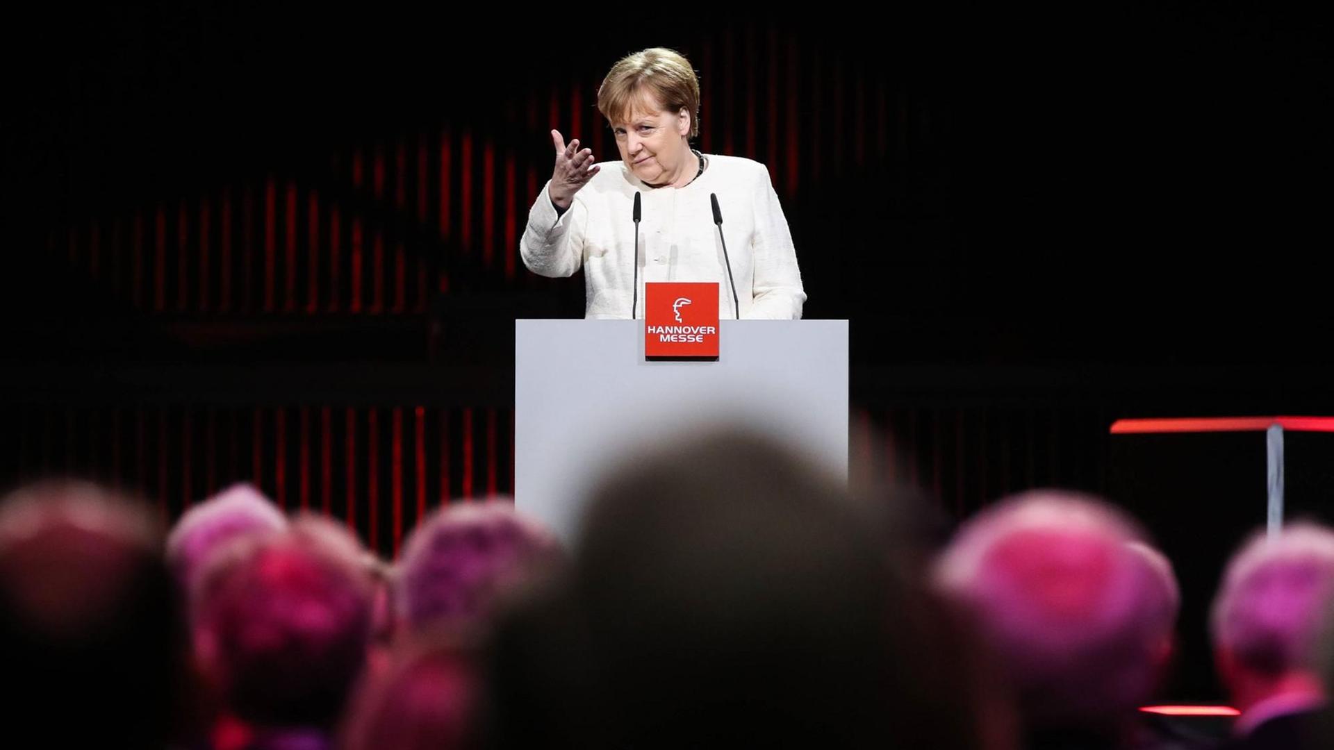 Bundeskanzlerin Angela Merkel auf der Industriemesse in Hannover im März 2019. Angela Merkel steht an einem Podium und hält eine Rede. Bundeskanzlerin Angela Merkel auf der Industriemesse in Hannover im März 2019. Angela Merkel steht an einem Podium und hält eine Rede.