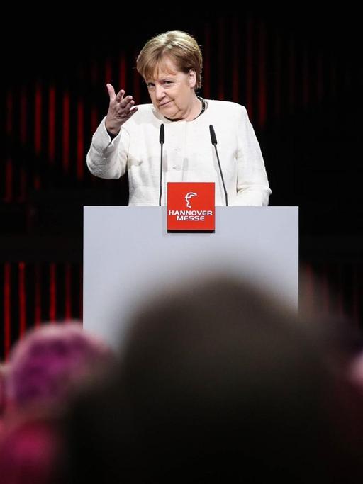 Bundeskanzlerin Angela Merkel auf der Industriemesse in Hannover im März 2019. Angela Merkel steht an einem Podium und hält eine Rede.