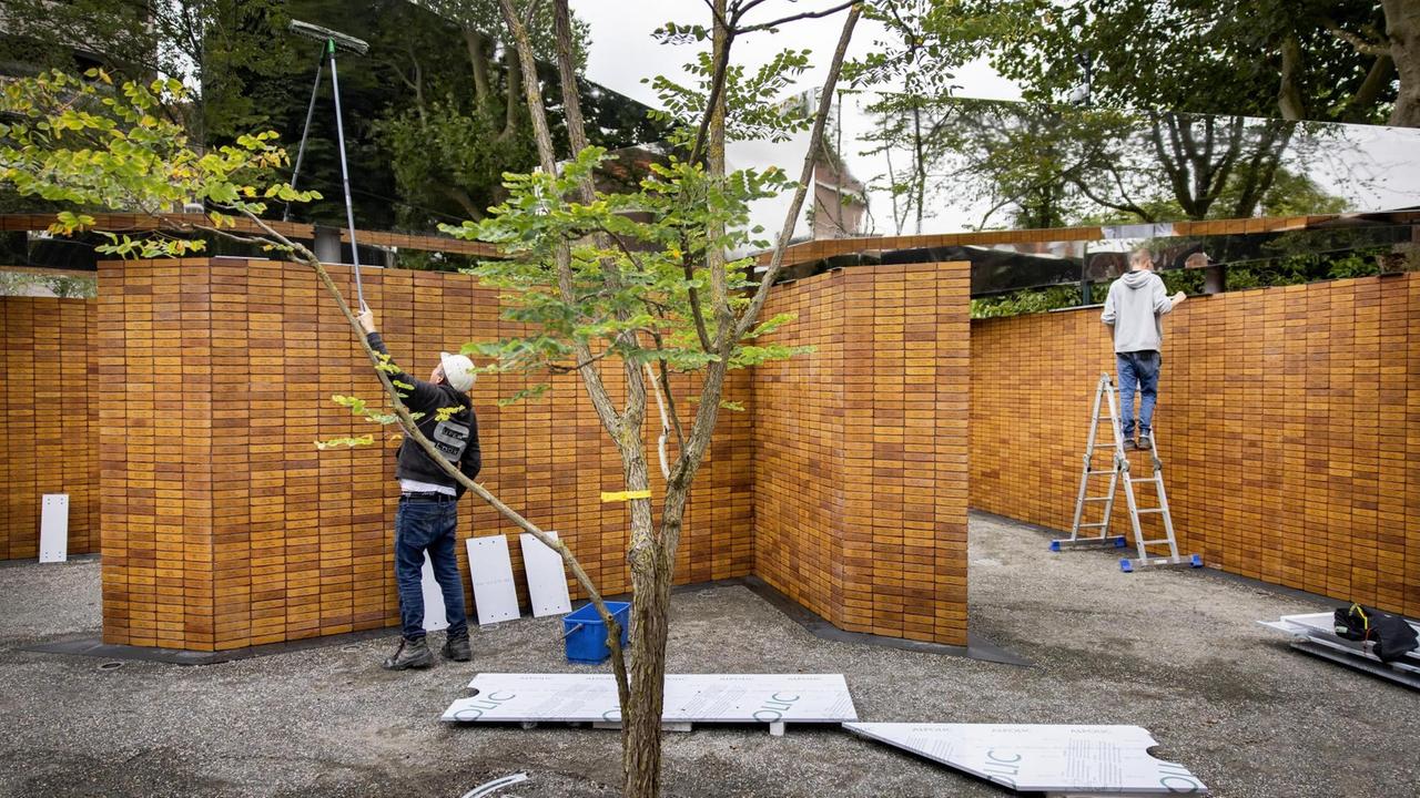 Gärtner und Reinigungskräfte bereiten das Mahnmal für seine Eröffnung vor.
